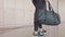 Closeup of sport woman lower body walking into fitness gym with outfit clothes bag for workout training. Sporty girl prepare to