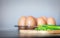 Closeup spring onion on wood butcher and fresh chicken egg in bowl and group of egg in box on wooden kitchen table for healthy and