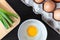 Closeup spring onion on wood butcher and fresh chicken egg in bowl and group of egg in box on wooden kitchen table for healthy and