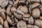 Closeup of stack of dark brown roasted coffee beans