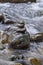 Closeup of stacked rocks in flowing water