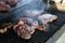 Closeup of steaks cooking on a BBQ