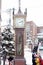 Closeup steam clock tower of Otaru music box museum with tourists on heavy snow day.