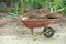 Closeup steel cart carrying the soil with shovels with blurred pile of soil and landscape in background
