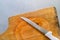 Closeup steel knife on a cutting board on metal background.