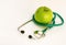 Closeup on stethoscope and apple on table