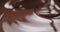 Closeup stirring molten dark chocolate with spoon