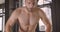 Closeup straight portrait of adult shirtless muscular caucasian man jumping on the box in the gym indoors