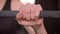 Closeup straight shoot of young attractive athlete female hands getting ready to lift weights in the gym indoors