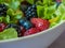 Closeup of strawberries, blueberries, raspberries, Blackberries and lettuce in a white bowl