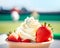 Closeup strawberries with wipped cream in white cream bowl on blurred tennis court