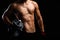 Closeup of a strength fitness body with dumbbell. Fit young man with beautiful torso. Beginner Bodybuilder and muscular body