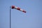 Closeup of striped windsock waiving in the wind against bright blue sky