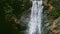 Closeup strong wild mountain waterfall on dark stone cliff at tropical jungles