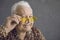 Closeup studio portrait of happy funny rich senior man in trendy yellow sunglasses
