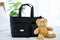 Closeup studio shot of black color multifunction multipurpose utility newborn toddler accessories handbag on bed with teddy bear