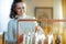 Closeup on stylish woman choosing sweaters hanging on rack