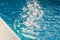 Closeup of swimingpool with clean blue water and sun rays summer background