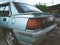 Closeup of the taillight of an old beat-up blue car