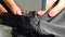 Closeup of tailor. Female hands of a seamstress at work. Sewing with a sewing machine with black material. Black lace