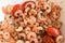 Closeup of tasty boiled caridean shrimps with seasonings and tomatoes
