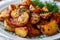 closeup of tasty rustic potatoes with spices on a white plate