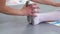 Closeup teacher hands stretching little ballerina foots in white shoes in ballet dance school