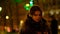 Closeup teenage girl with long hair walking along the street,listening to the music wearing headphones at night under