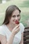 Closeup of teenage girl relaxing in the park, eating a ice creame, on a bench. Smiling young woman. Summer time, outdoor