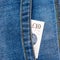 Closeup of ten pounds sterling banknote peeking out of blue jeans back pocket