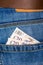 Closeup of ten and twenty pounds sterling banknotes peeking out of blue jeans back pocket