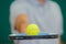 Closeup tennis ball balancing on racket