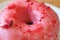 Closeup the texture of mouthwatering strawberry-glazed doughnut