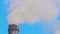 Closeup of thermal power plant high pipes with black smoke moving upwards polluting atmosphere. Production of electrical