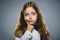 Closeup Thoughtful Young girl Looking Up with Hand at Face isolated on Gray Background