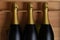 Closeup of three Champagne bottles in a wood case