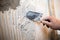 Closeup of a tiler applying adhesive to a tile