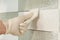 Closeup of tiler hand rubbing tile, Installing and grouting decorative finishes in environments with an high aesthetic value. Two-