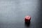 Closeup to a lonely red dice over a black background.