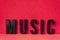 Closeup to a MUSIC black lettering word over a red background