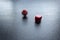 Closeup to a red dices, one dice is spinning over a black background.