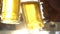 Closeup toast clinking lager beer glasses mugs with sun rays