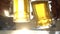 Closeup toast clinking lager beer glasses mugs with sun rays