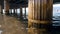 Closeup toned image of old wooden column under sea pier