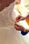 Closeup toned photo of beautiful bride tying up her wedding dress