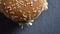 Closeup top down view of double cheeseburger with sesame on the buns rotating in motion