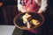 Closeup top view of hands of kid holding piece of birthday cake with burning colorful candles. Horizontal color