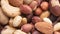 Closeup top view of mixed nuts over a wooden background. Peanuts, brazilian nuts, cashew, baru and almonds