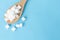 Closeup top view sugar cubes on wooden spoon white blue background