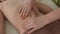 Closeup top view of unrecognizable female pediatric masseuse making therapeutic massage to teen boy on tummy in clinic